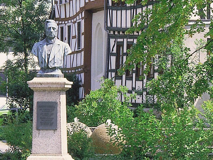Grüne Umgebung mit Statue und traditionellem deutschen Architektur