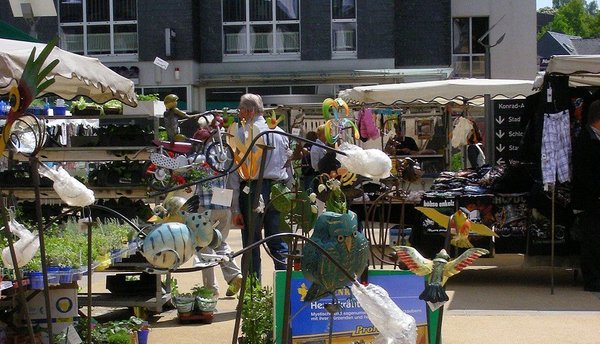 Bunte Figuren und Stände auf einem Außenmarkt bei schönem Wetter