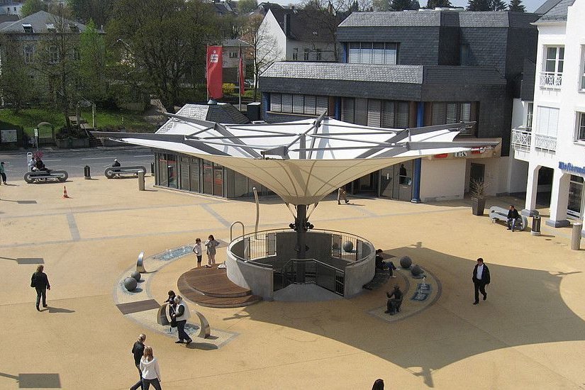 Ein öffentlicher Platz mit einem modernen Pavillon und Besuchern