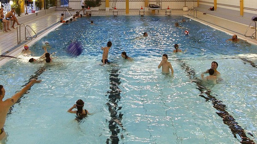 Besucher genießen das Schwimmen und Ballspiele im Hallenbad