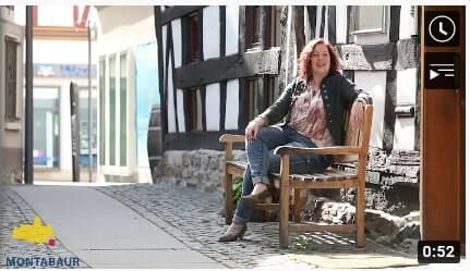 Entspannte Szene in Montabaur mit Frau auf Bank in einer Gasse