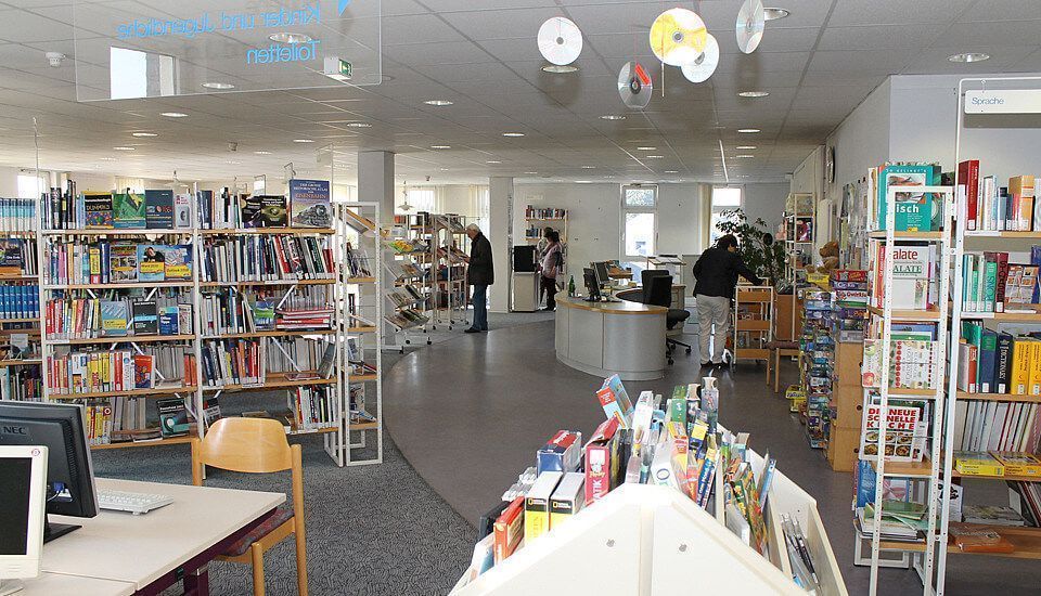 Regal mit Büchern und einem Empfangstresen in einer Bibliothek